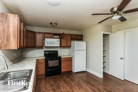 A kitchen with a black oven and white fridge.