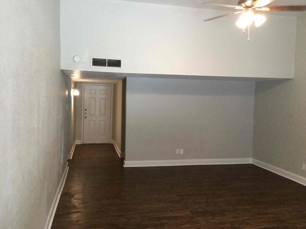 A room with a ceiling fan and a door.