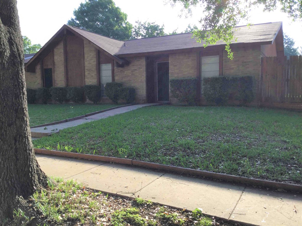 A brown house with a white door and windows.