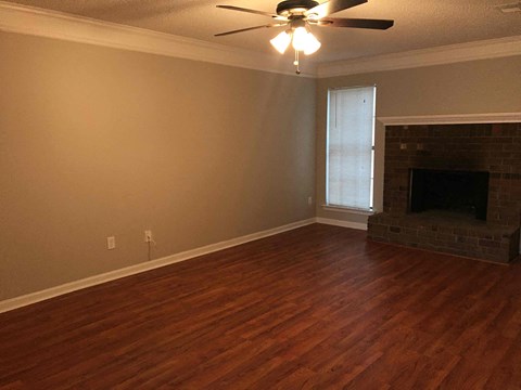 a living room with a fireplace and a ceiling fan