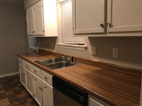 a kitchen with a wooden counter top and a sink