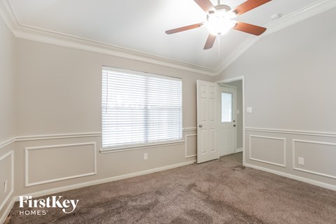a living room with a ceiling fan and a white door