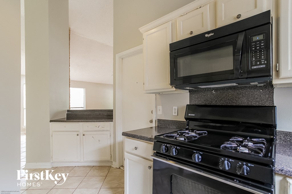 a kitchen with black appliances and white cabinets