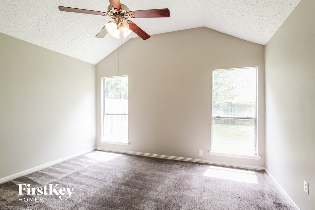 a living room with a ceiling fan and a window