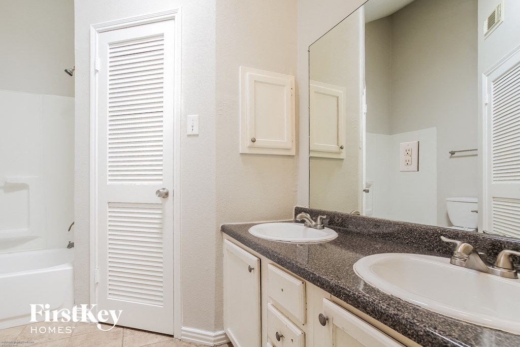 a bathroom with two sinks and a large mirror