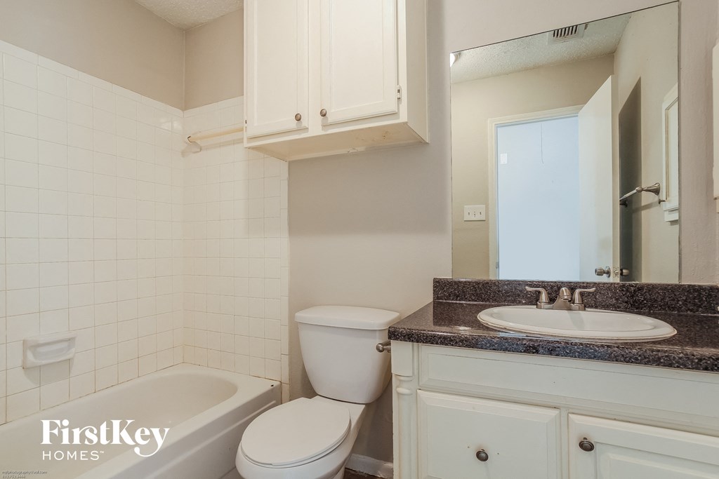 a white bathroom with a sink toilet and bath tub