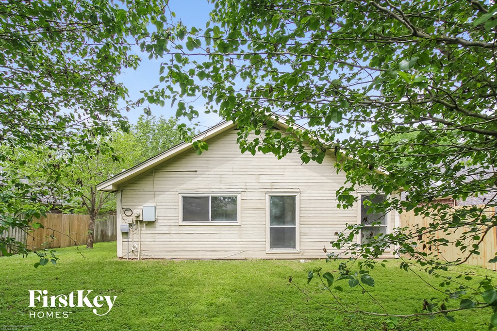 a small white house in the middle of a yard