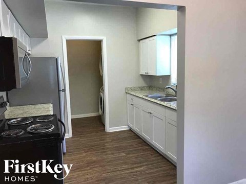 A kitchen with a stove top oven and a refrigerator.