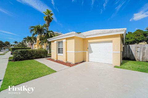 a yellow house with a driveway and a white garage door