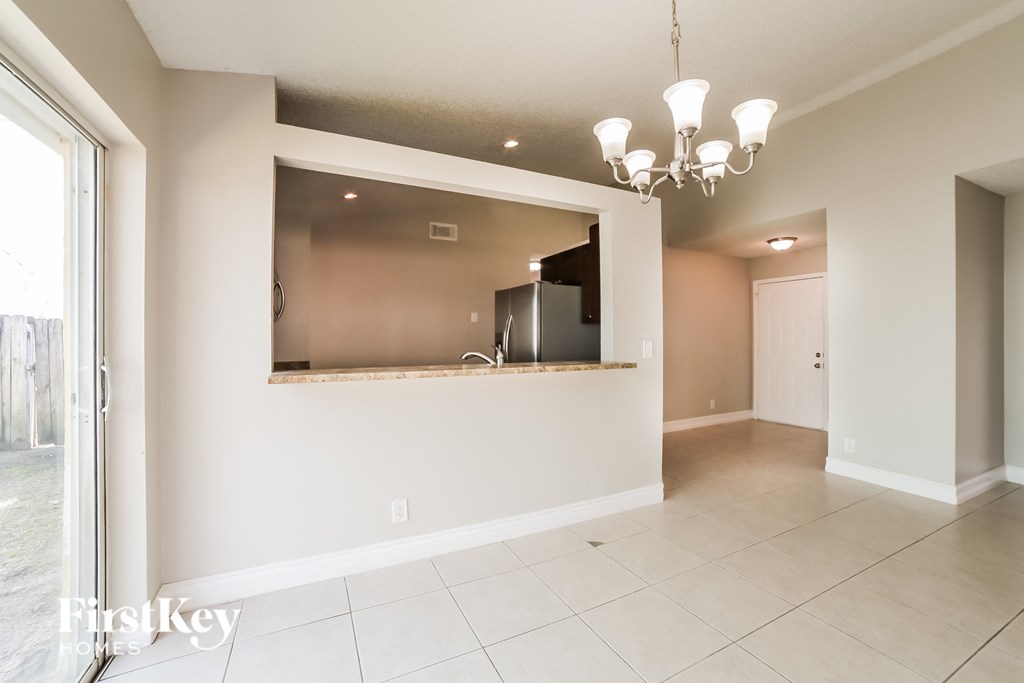 a kitchen and living room with a large mirror on the wall