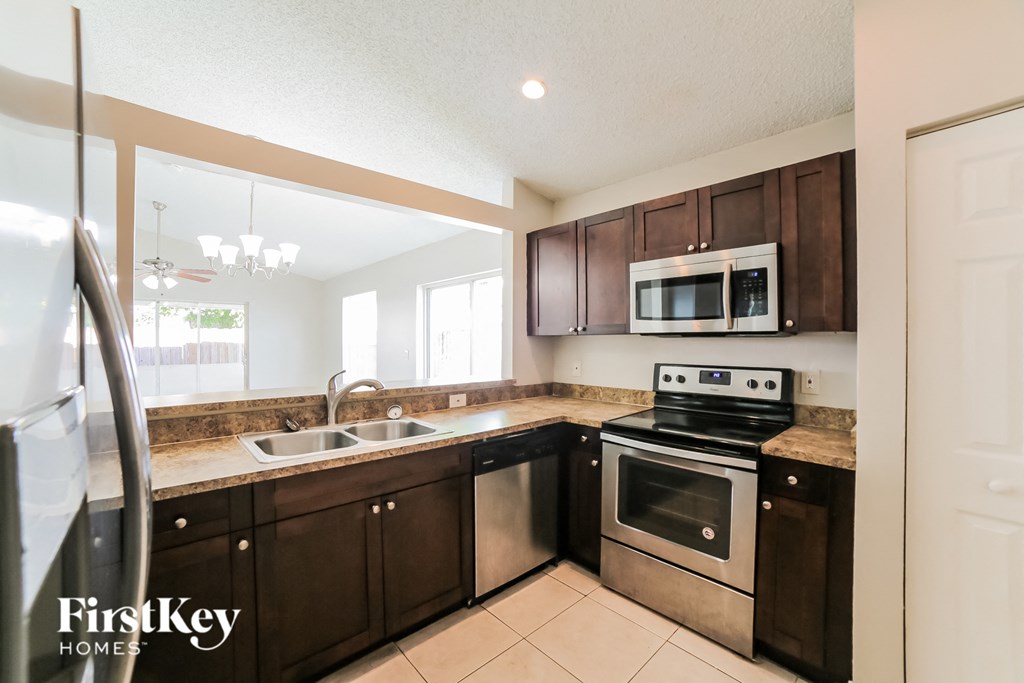 a kitchen with wooden cabinets and stainless steel appliances