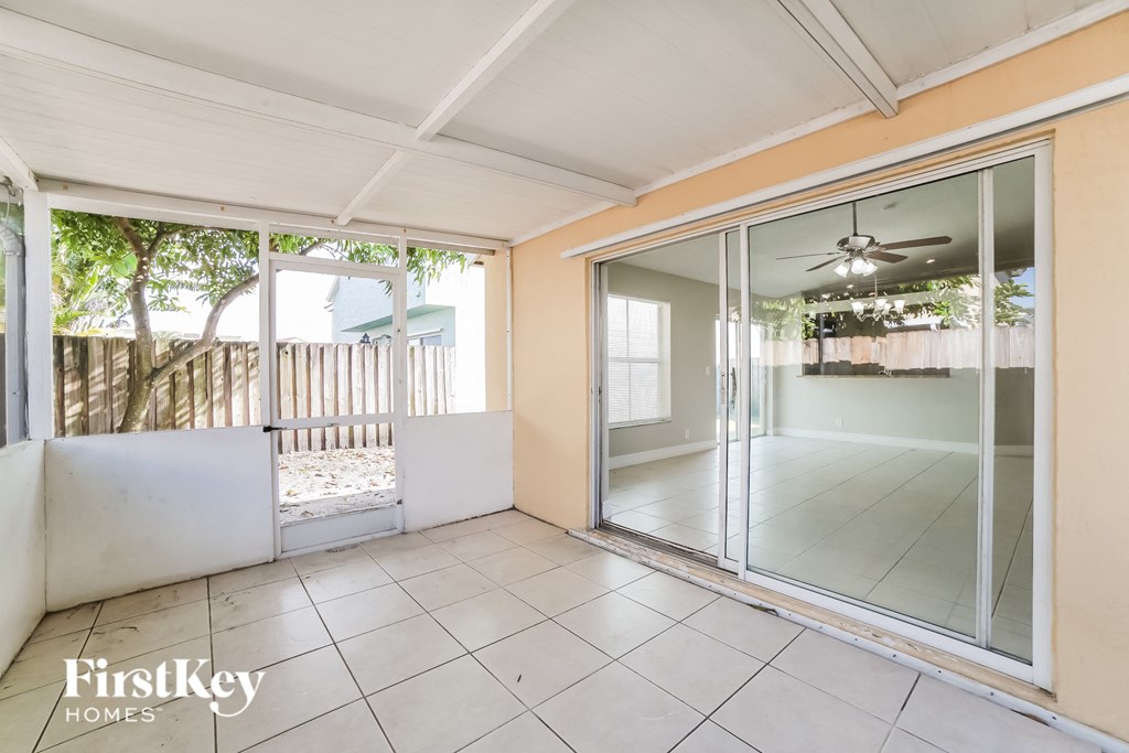 a patio with glass sliding glass doors and a tiled floor