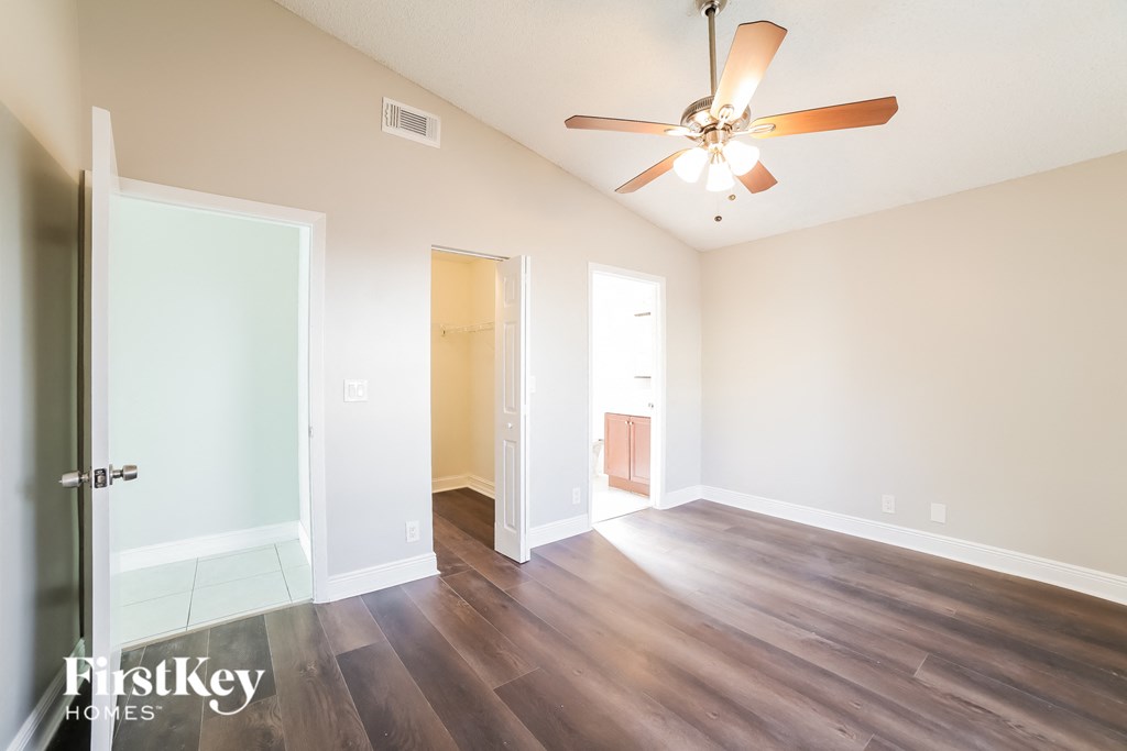 a living room with hardwood flooring and a ceiling fan