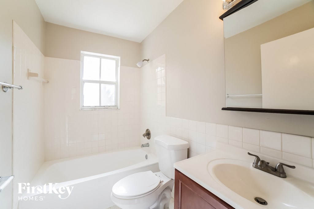 a bathroom with a sink toilet and tub and a mirror