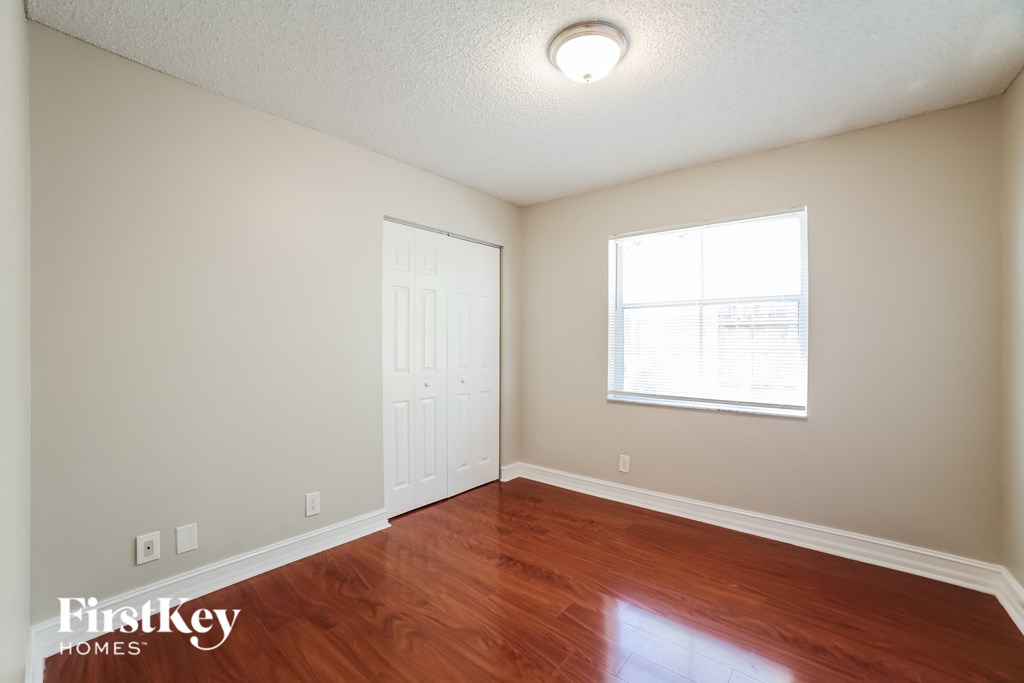 a living room with wood flooring and a window and a white door