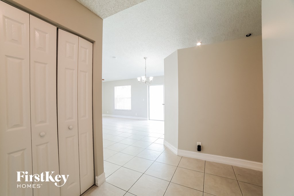 the living room and dining room with white closets and tiled flooring