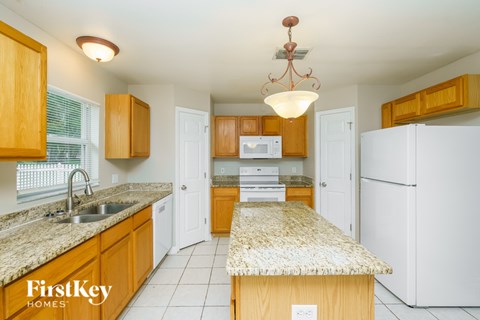 A kitchen with wooden cabinets and a granite countertop.