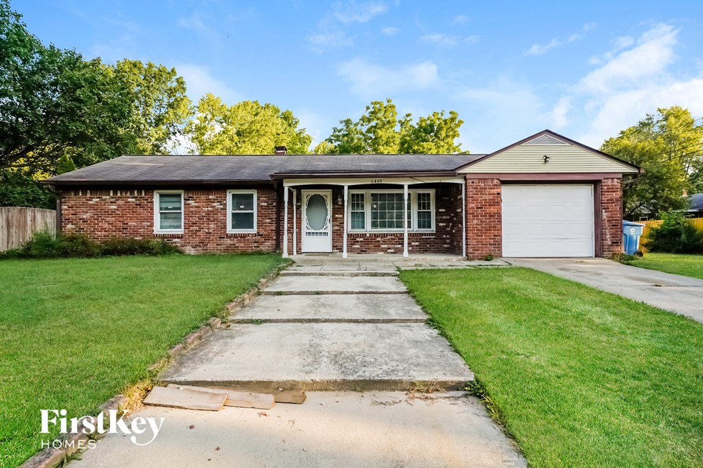 a brick house with a white garage door and a lawn
