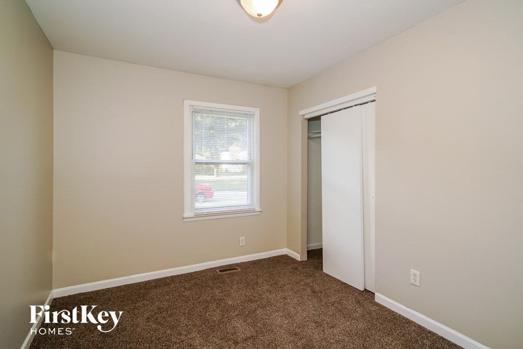a bedroom with carpet and a door to a closet