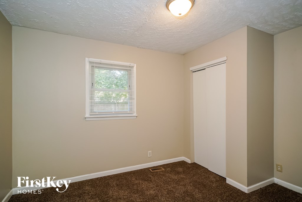 a bedroom with a door to a closet and a window