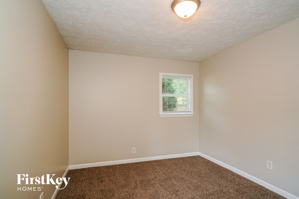 a bedroom with a carpeted floor and a window
