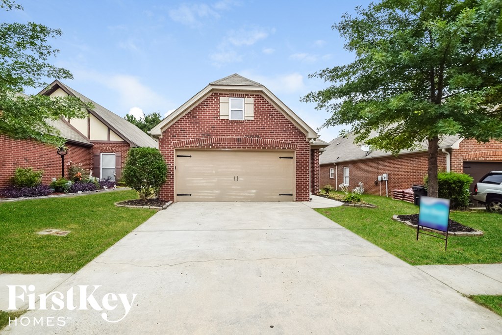 A brick house with a garage is for sale.