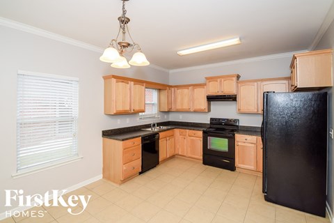 A kitchen with wooden cabinets and black appliances.