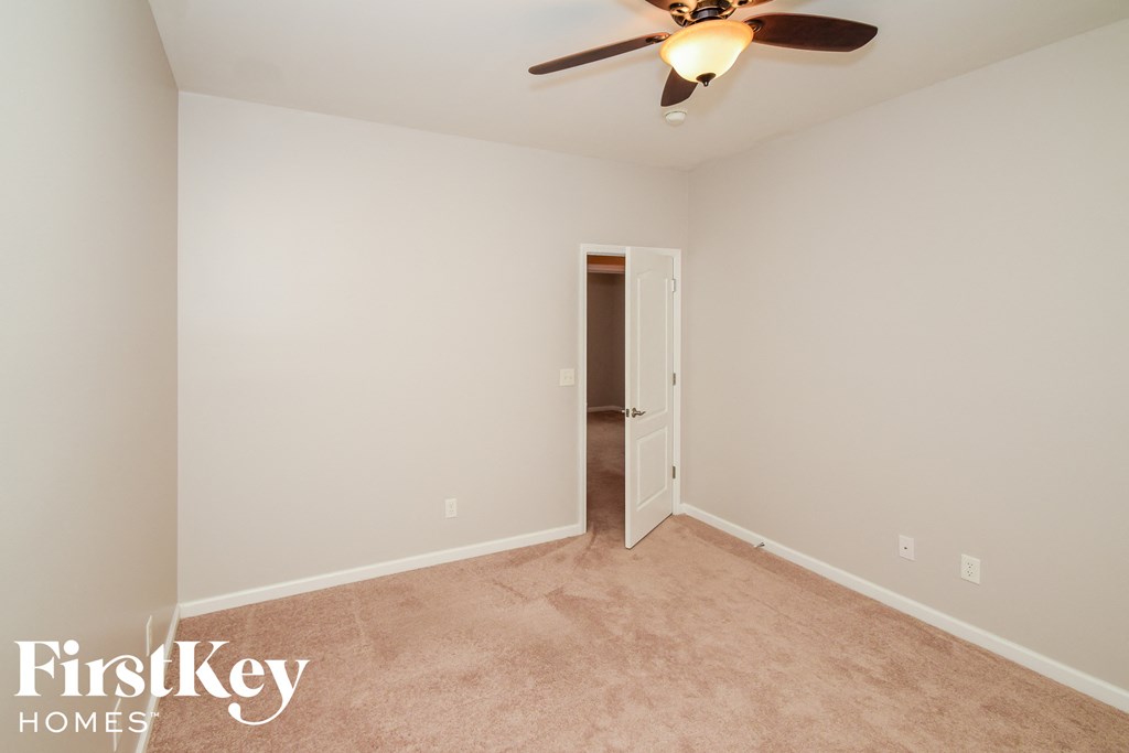 A room with a ceiling fan and a door.
