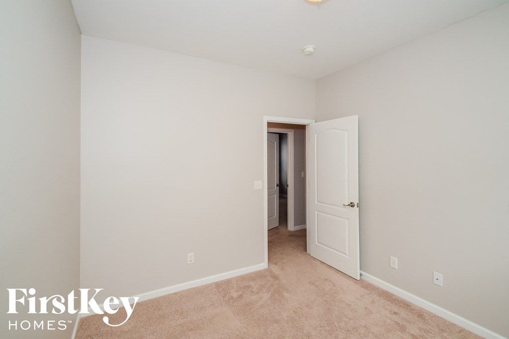 A room with a carpeted floor and a doorway leading to another room.