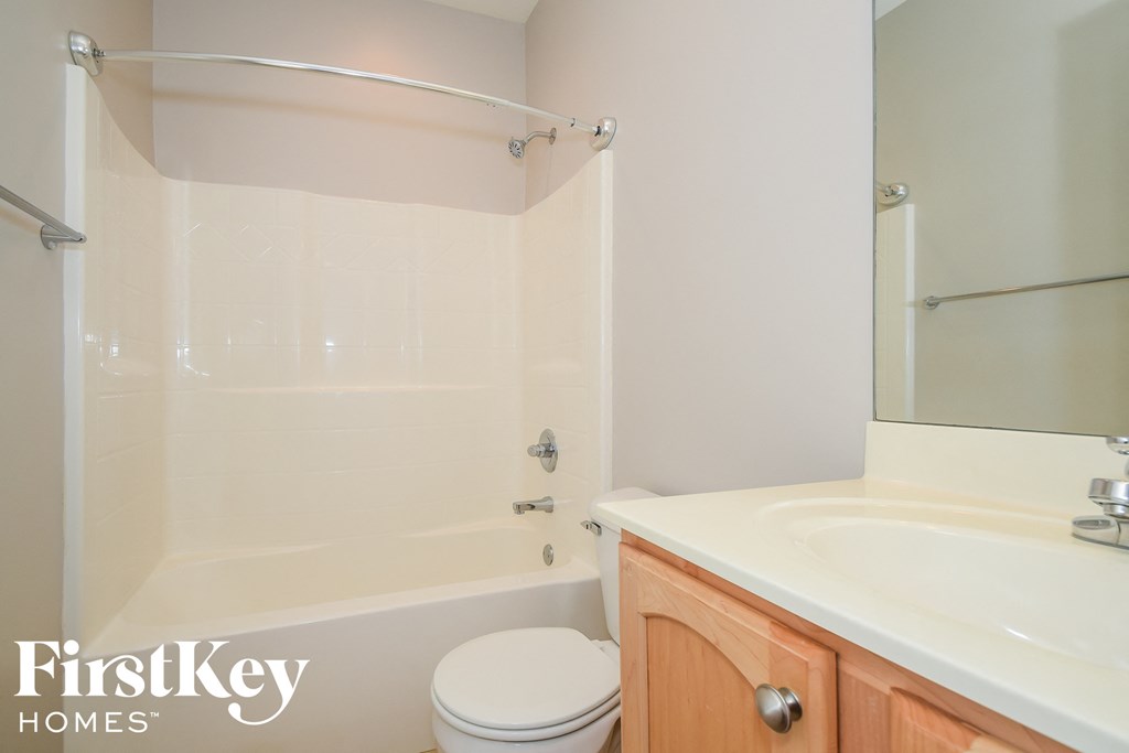 A white toilet sits next to a white sink in a small bathroom.