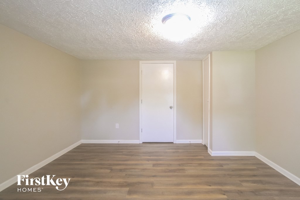 an empty living room with wood flooring and white walls