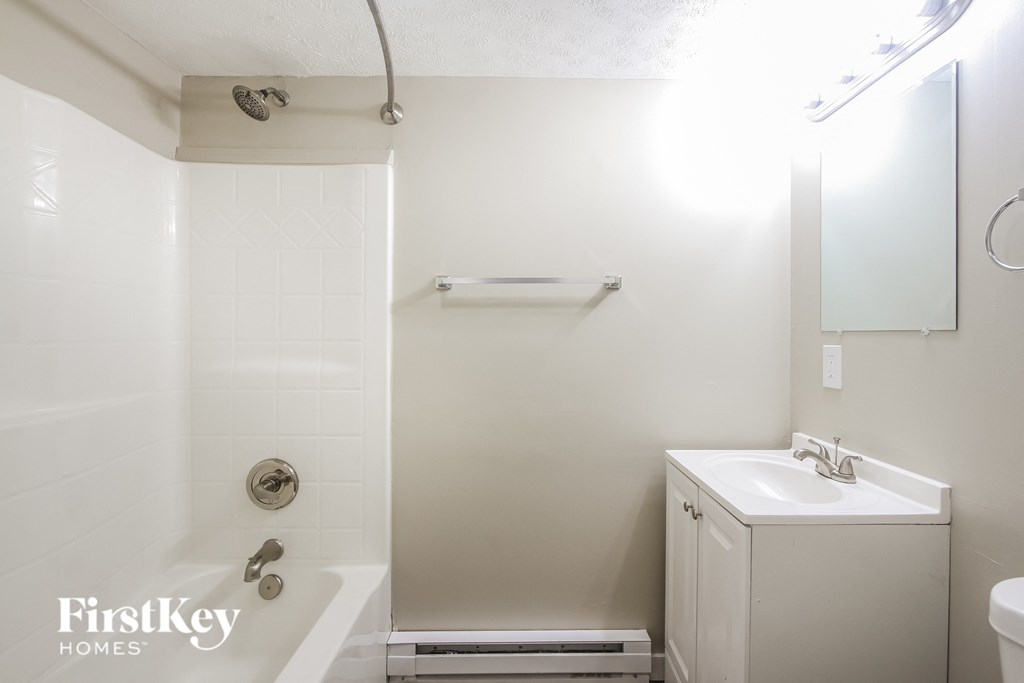 a white bathroom with a shower and a sink