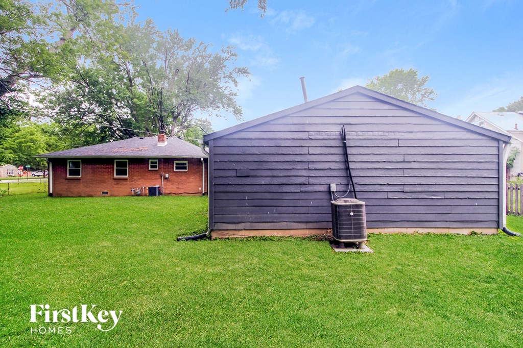 a backyard with a garage and a red brick house