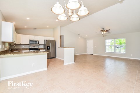 A spacious kitchen with a refrigerator, microwave, and oven.