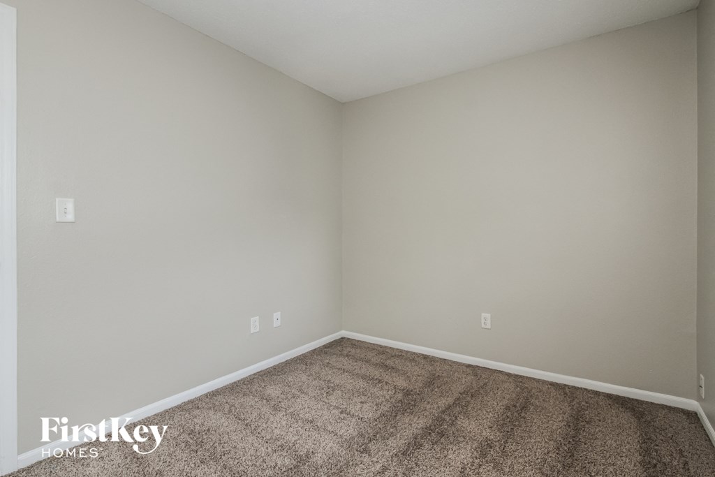 an empty room with carpet and white walls