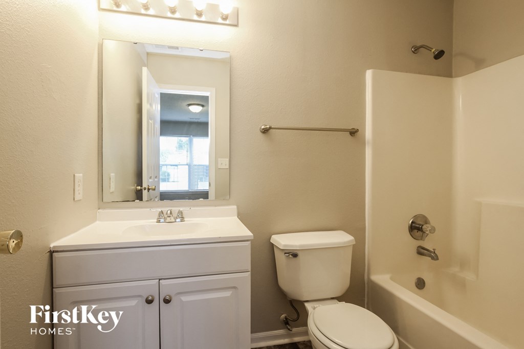 a bathroom with a toilet and a sink and a bath tub