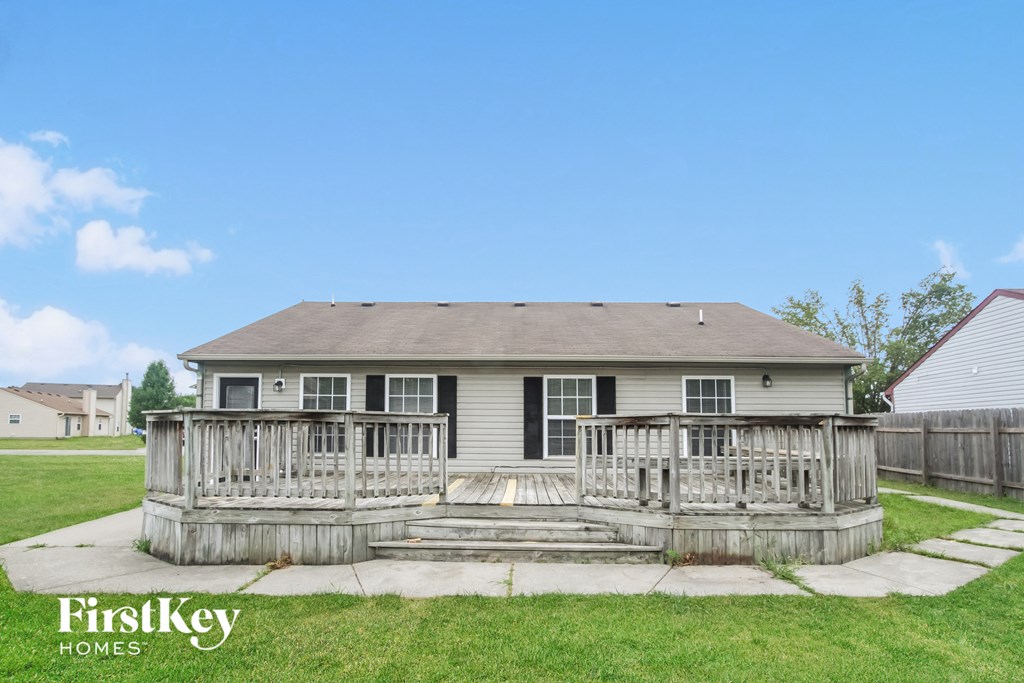 the back of a house with a wooden deck and a porch