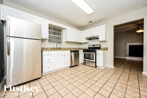 A kitchen with white cabinets and a stainless steel refrigerator.