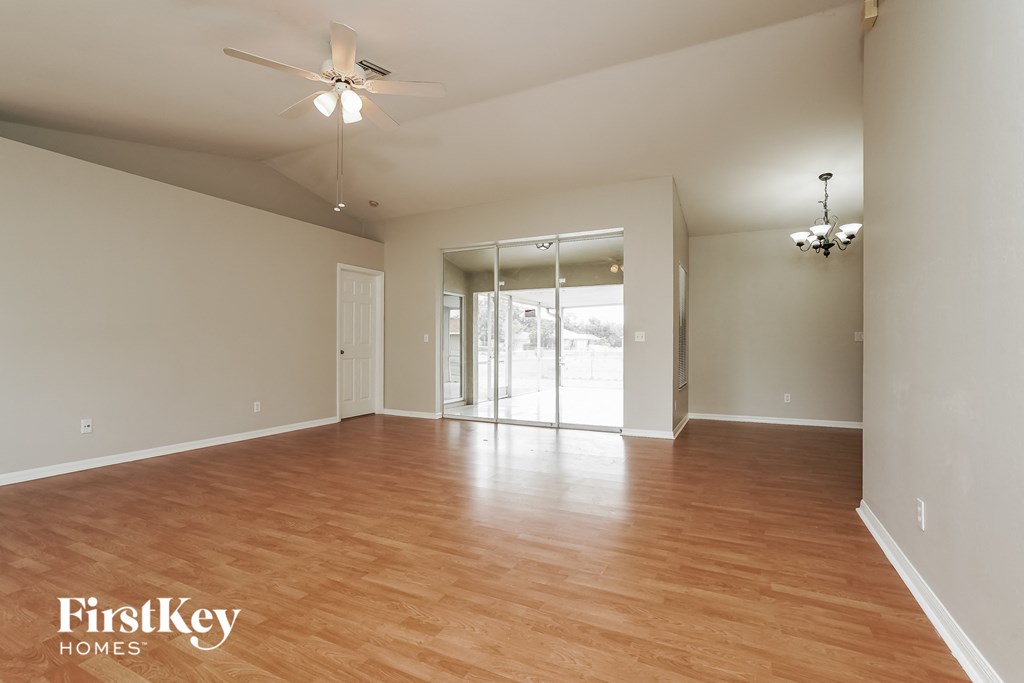 an empty living room with wood flooring and sliding glass doors