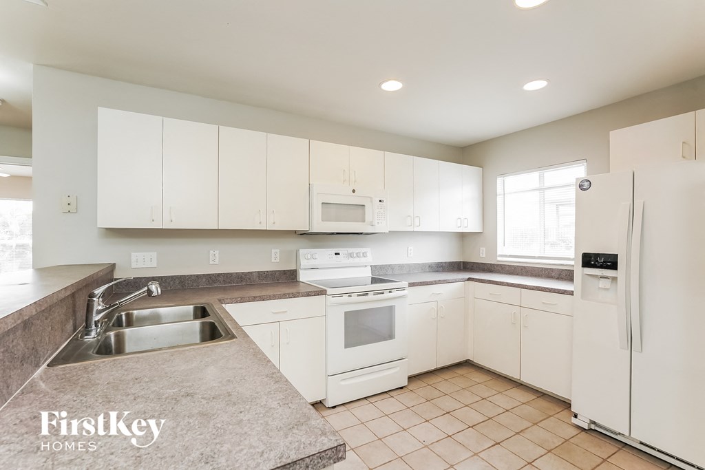 a white kitchen with white appliances and white cabinets