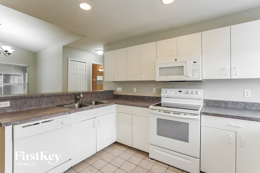 a kitchen with white appliances and white cabinets