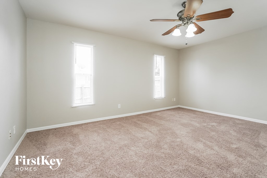 a bedroom with carpet and a ceiling fan