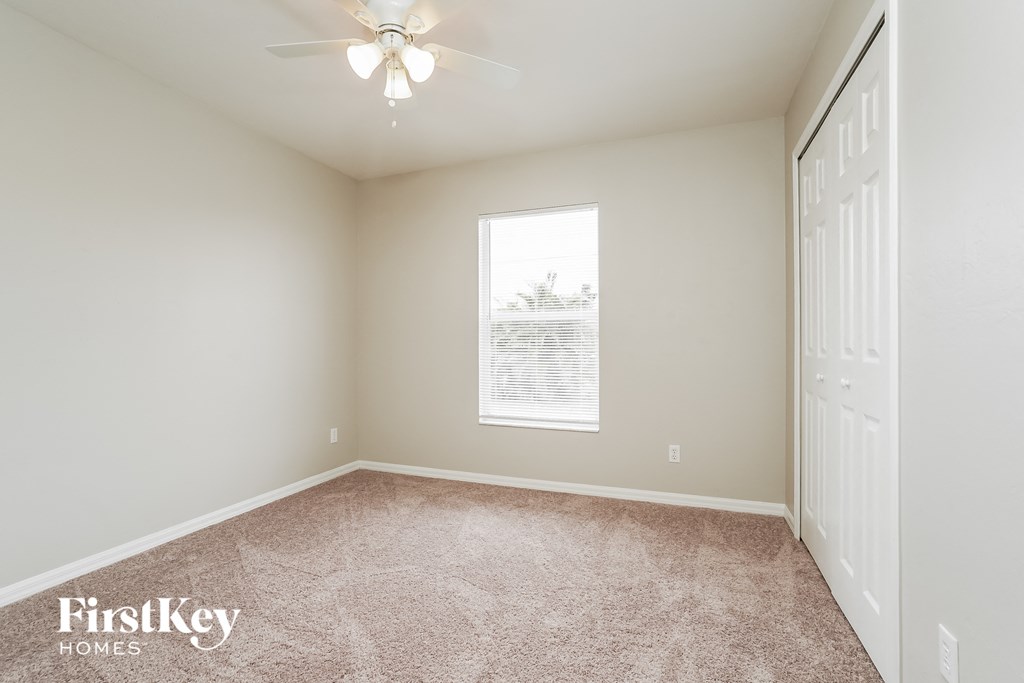a bedroom with a ceiling fan and a window