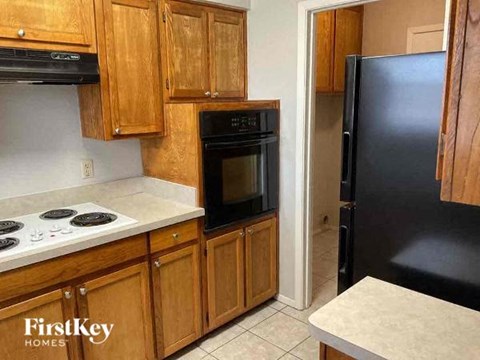 A kitchen with wooden cabinets and black appliances.