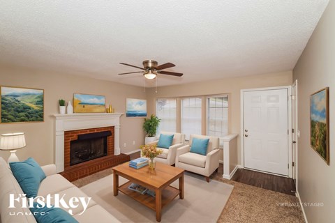 A living room with a fireplace and a painting on the wall.