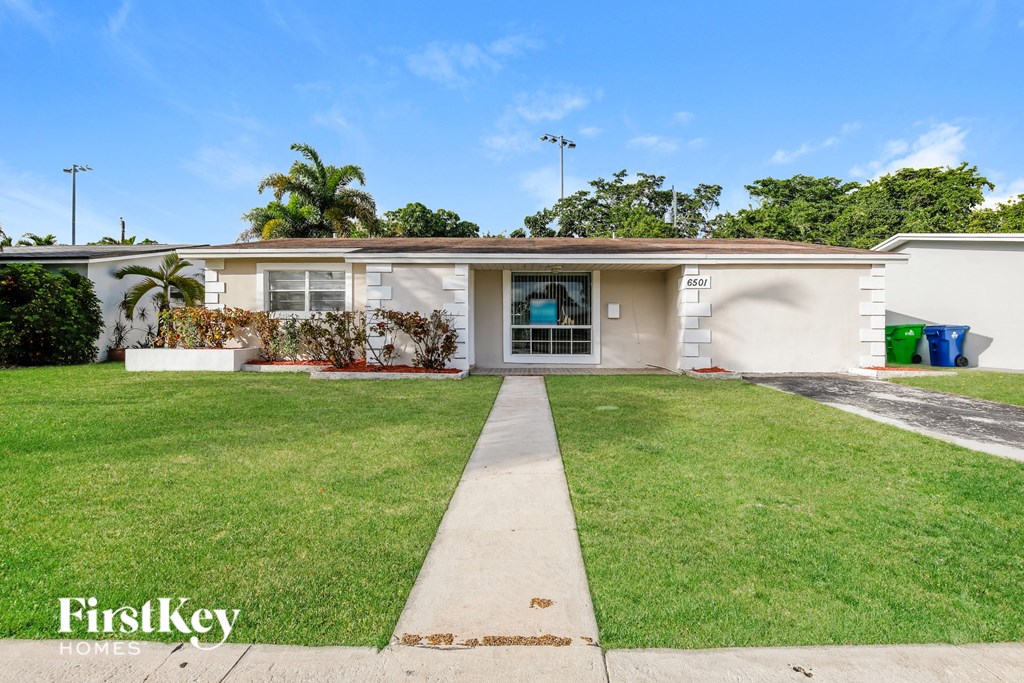 a white house with a lawn and a driveway