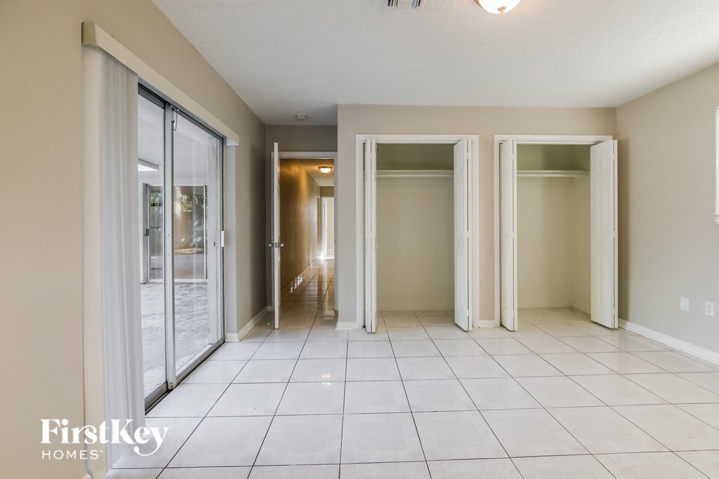 an empty living room with sliding glass doors and a tiled floor