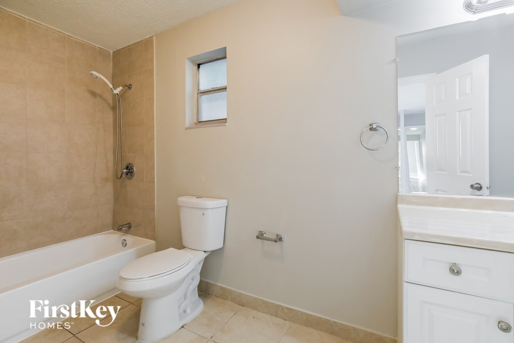 a bathroom with a toilet and a tub and a sink