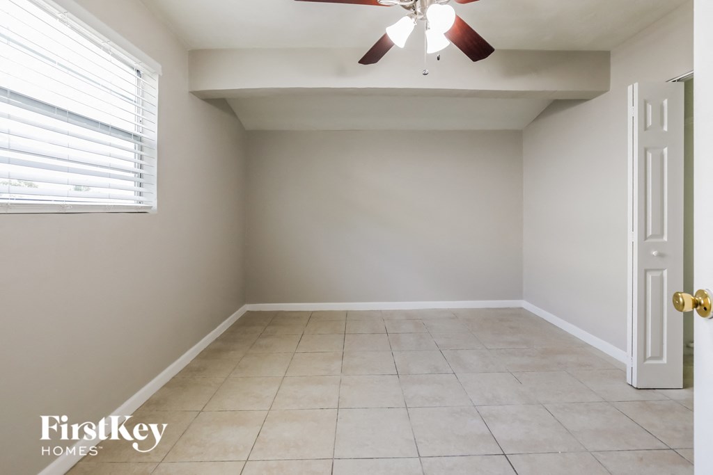an empty room with a ceiling fan and a window