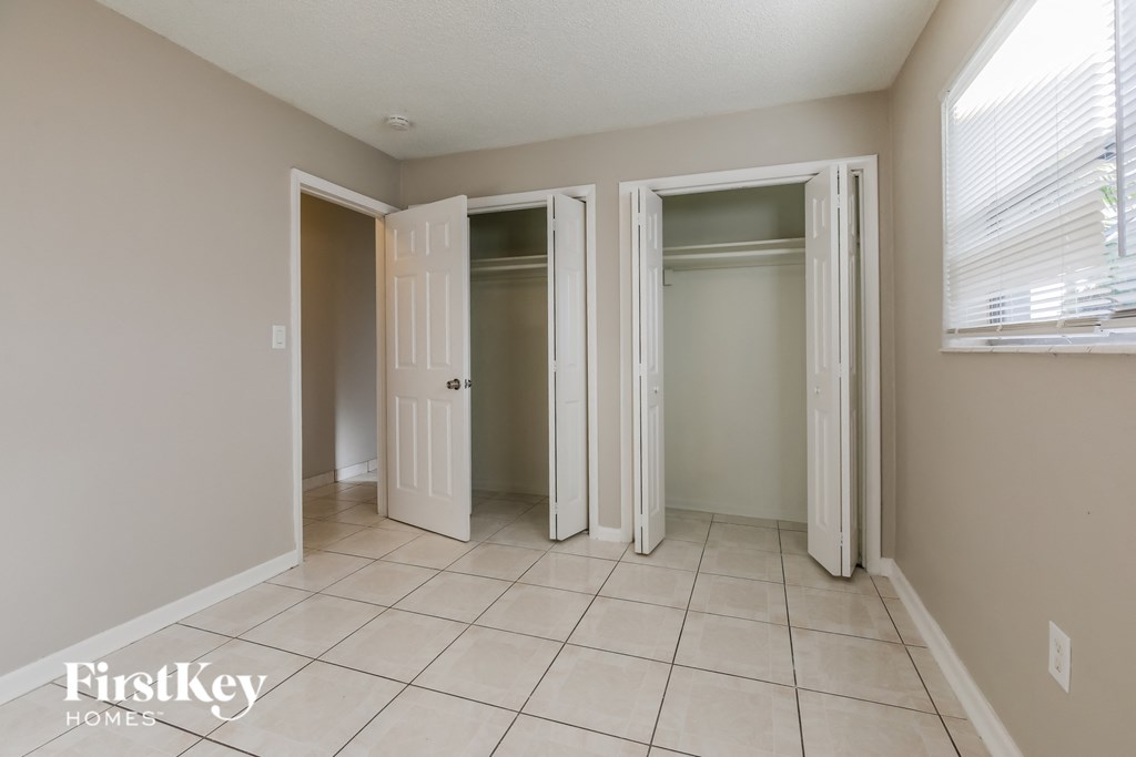 an empty room with three closets and a tiled floor